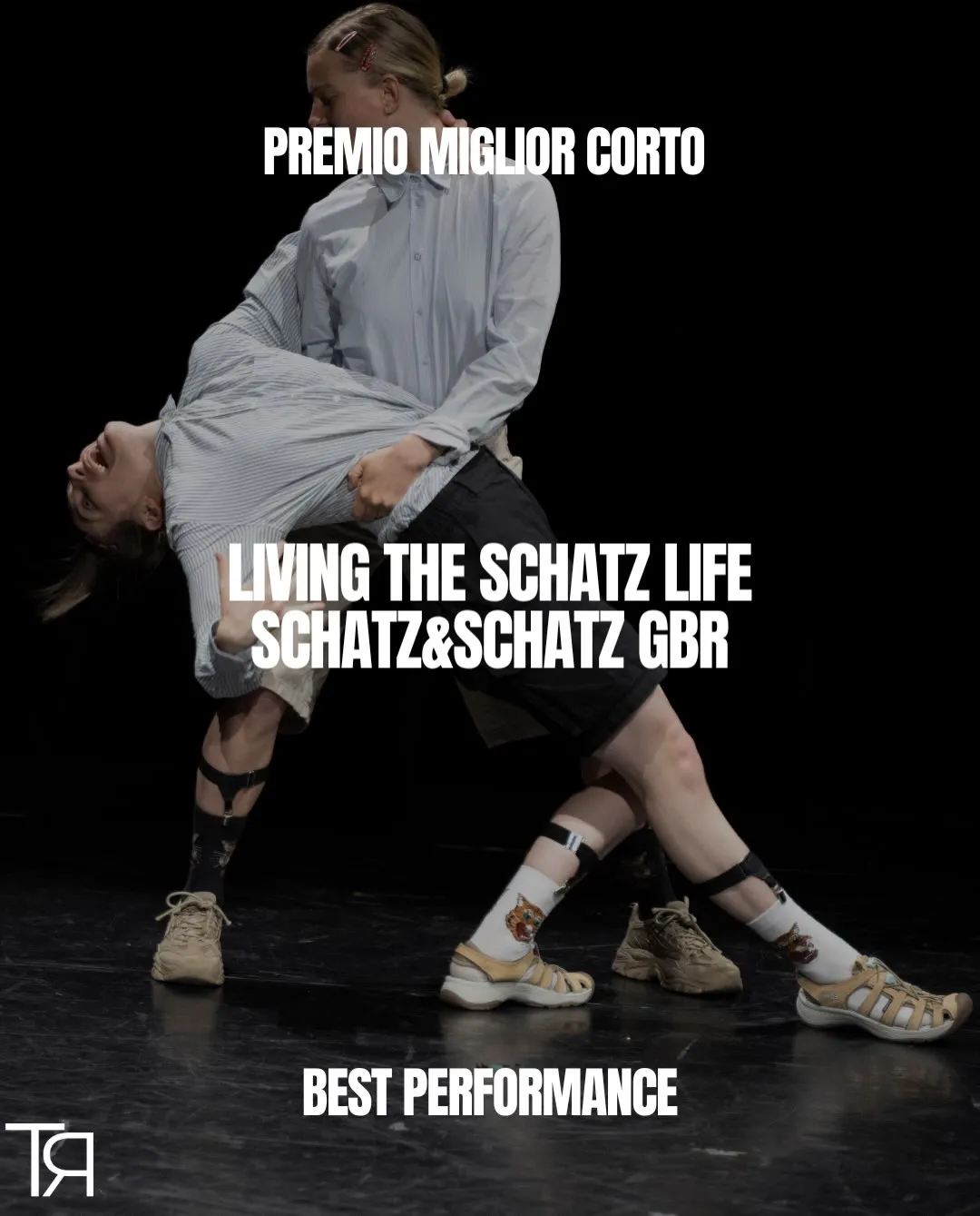 Scene from Living the Schatz Life: Fine Kroke and Alexandra Entenmann in motion on a dark stage. Award graphic by the Teatri Riflessi Festival reading "Premio Miglior Corto – Best Performance"